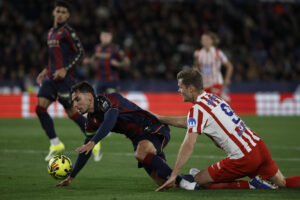 El defensa argentino del Levante, Matías Moreno (i), cae ante el delantero noruego del Atlético de Madrid, Alexander Sorloth, durante el encuentro correspondiente a la jornada 22 de LaLiga EA Sports entre Levante UD y Atlético de Madrid celebrado en el Estadio Ciutat de València. EFE/ Biel Aliño