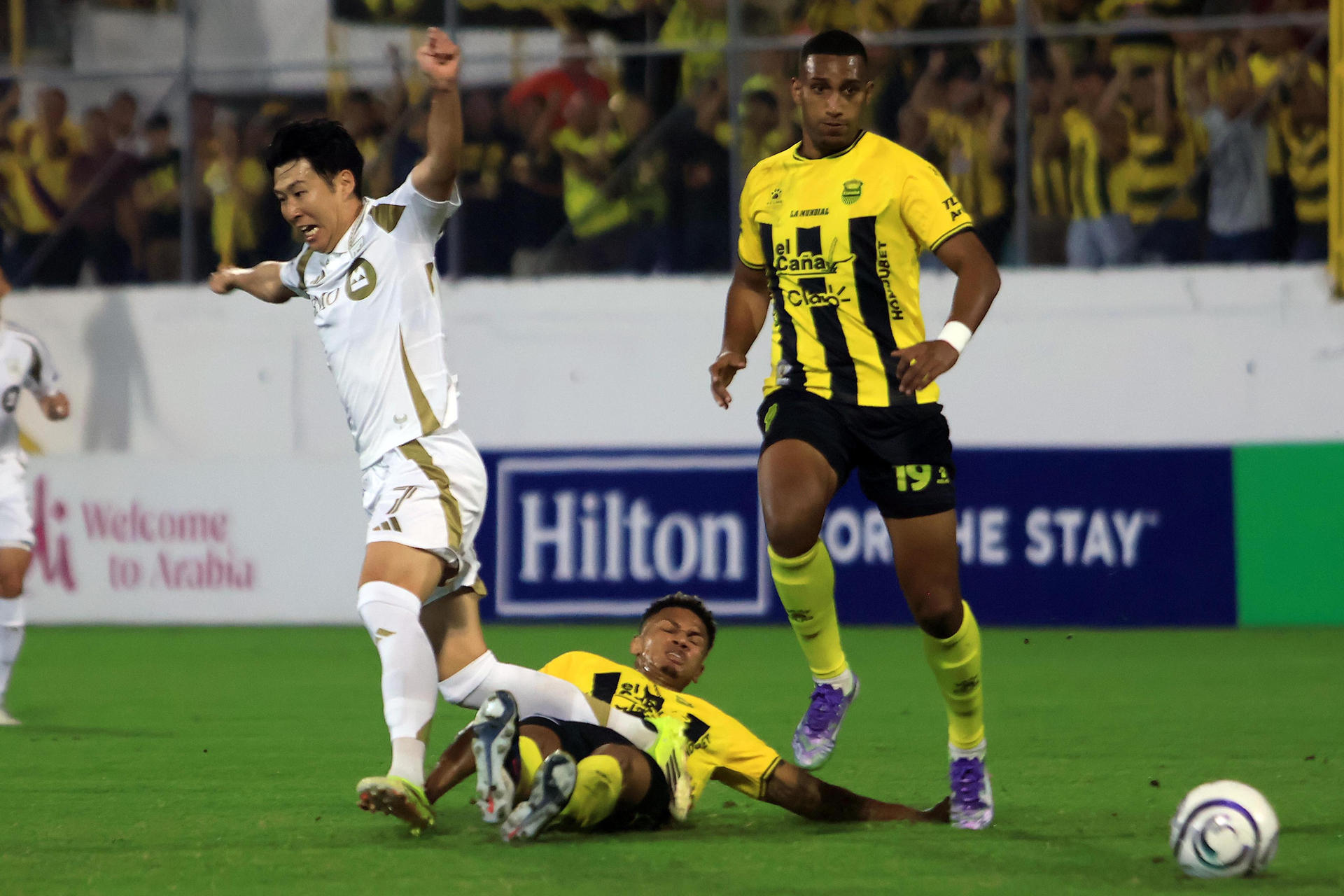 Jack Baptiste (c) y Daniel Aparicio, del Real España, disputan un balón con Heung-Min Son, de Los Ángeles FC, en un partido de la Copa de Campeones de Concacaf entre Real España y Los Ángeles FC en el estadio General Francisco Morazán en San Pedro Sula (Honduras). EFE/José Valle
