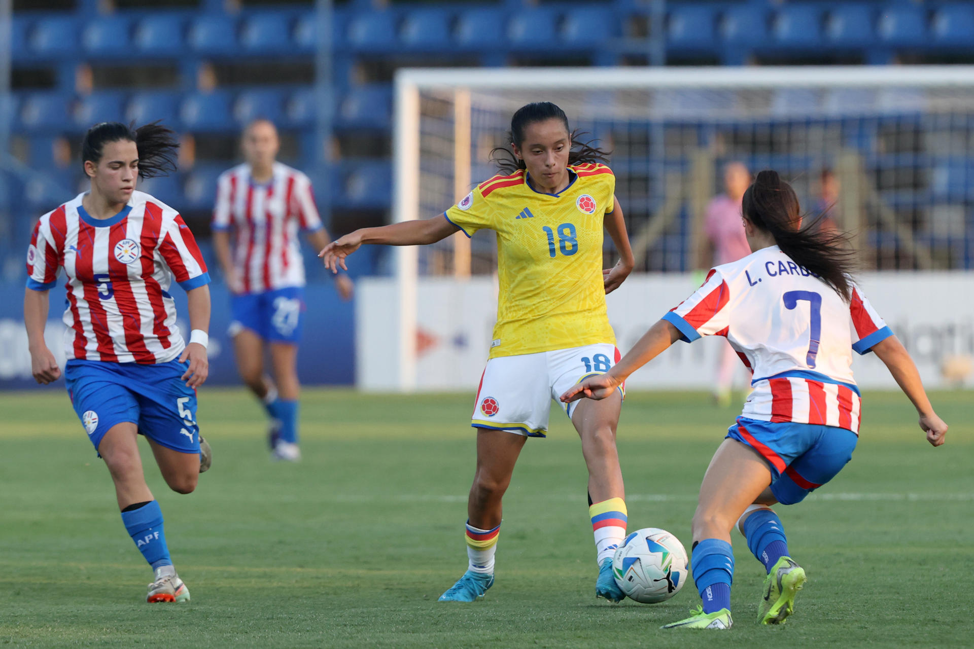 Kiara Florentin (i) y Luz Cardozo, de Paraguay, disputan un balón con Katerine Osorio, de Colombia, este jueves en un partido del Sudamericano Femenino Sub-20 en el estadio Luis Alfonso Giagni en Villa Elisa (Paraguay). EFE/ Juan Pablo Pino