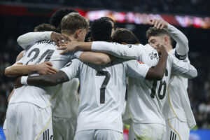 El delantero del Real Madrid Vinicius Jr. (c) celebra su segundo gol, cuarto del equipo blanco, durante el partido de la jornada 24 de LaLiga entre el Real Madrid y la Real Sociedad, este sábado en el estadio Santiago Bernabéu. EFE/JuanJo Martín