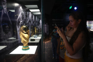 Una mujer toma una fotografía a una réplica de la Copa Mundo de la FIFA este viernes en el Museo Conmebol en Luque (Paraguay). EFE/ Juan Pablo Pino