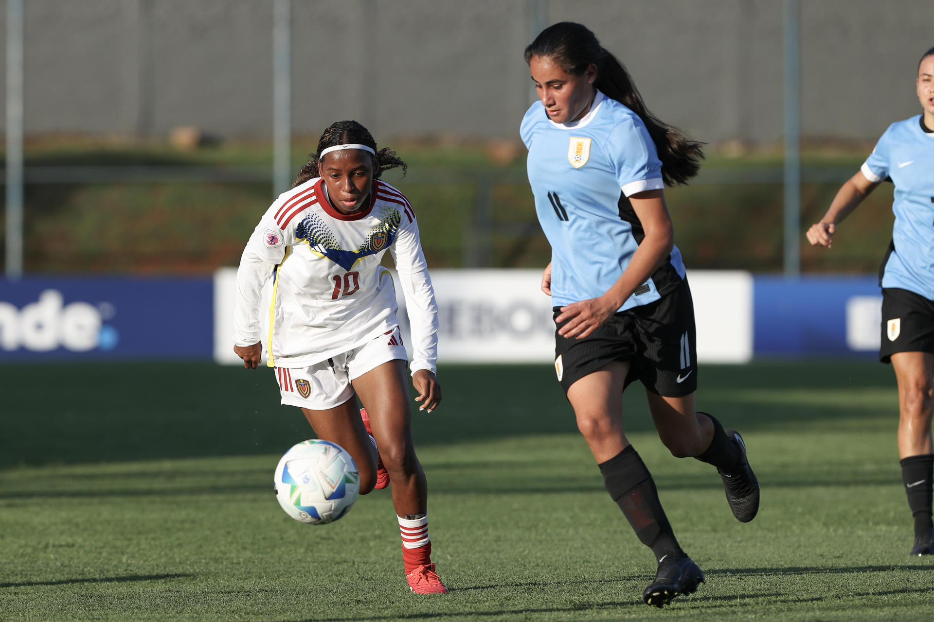 Valentina Pereira (d), de Uruguay, disputa el balón con Ailing Herrera, de Venezuela, en un partido del Sudamericano Femenino Sub-20 entre Uruguay y Venezuela en el estadio Emiliano Ghezzi, en Asunción (Paraguay). EFE/Juan Pablo Pino 