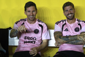 Lionel Messi (i) y Rodrigo De Paul sonríen este jueves desde el banco de suplentes durante el partido amistoso entre el Inter Miami y el Independiente del Valle ecuatoriano, jugado en Bayamón (Puerto Rico). EFE/ Thais Llorca