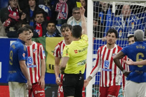 El colegiado muestra tarjeta amarilla al defensa del Atlético de Madrid Robin Le Normand durante el partido de LaLiga de fútbol que Real Oviedo y Atlético de Madrid disputaron en el estadio Carlos Tartiere. EFE/Paco Paredes