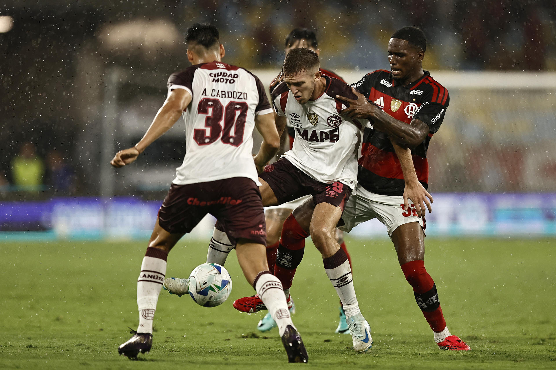 Evertton Araújo (d), de Flamengo, disputa el balón con Rodrigo Castillo (c), de Lanús, este jueves en un partido de vuelta de la Recopa Sudamericana en el estadio Maracaná, en Rio de Janeiro (Brasil). EFE/ Andre Coelho
