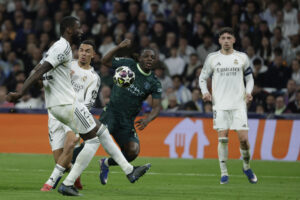 El delantero belga del Manchester City Jeremy Doku (d) disputa el balón ante los jugadores del Real Madrid, el alemán Antonio Rudiger y el británico Trent Alexander-Arnold, durante el encuentro correspondiente a la ida de los octavos de final de la Liga de Campeones que Real Madrid y Manchester City disputaron en el estadio Santiago Bernabéu, en Madrid. EFE/Kiko Huesca