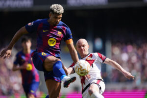 El jugador del FC Barcelona Ronald Araujo (i) lucha por el balón con Isi (d), del Rayo Vallecano, durante su partido de la jornada 29 de LaLiga EA Sports en el Camp Nou, este domingo. EFE/ Alejandro Garcia