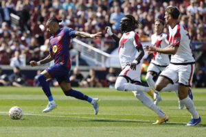 El jugador del FC Barcelona Raphinha (i) perseguido por el senegalés Pathé Ciss, del Rayo Vallecano, durante su partido de la jornada 29 de LaLiga EA Sports en el Camp Nou, el pasado domingo 22. EFE/ Toni Albir