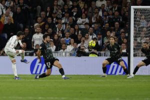 El centrocampista uruguayo del Real Madrid, Federico Valverde (i), golpea el balón en la jugada que ha significado el segundo gol del equipo madridista durante el encuentro correspondiente a la jornada 28 de Laliga EA Sports que disputan Real Madrid y Elche en el estadio Santiago Bernabéu, en Madrid. EFE / Sergio Pérez.