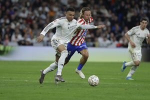 El delantero del Real Madrid Kylian Mbappé (i) escapa de Marcos Llorente, del Atlético, durante el partido de la jornada 29 de LaLiga que Real Madrid y Atlético de Madrid disputaron este domingo en el estadio Santiago Bernabéu. EFE/Juanjo Martín