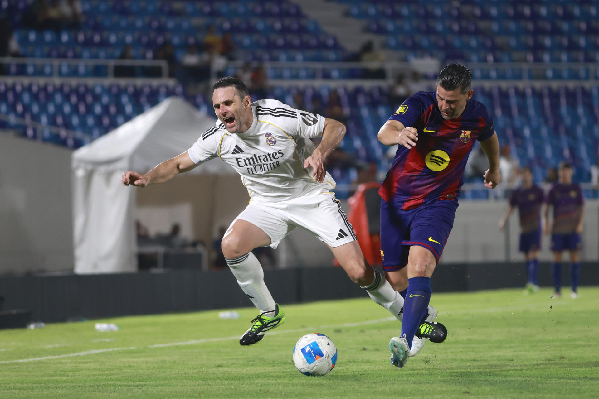 Nolito (d), del Barcelona, disputa el balón con Antonio Nuñez, del Real Madrid, en el partido de leyendas en el estadio Olímpico Félix Sánchez en Santo Domingo. EFE/Orlando Barría 