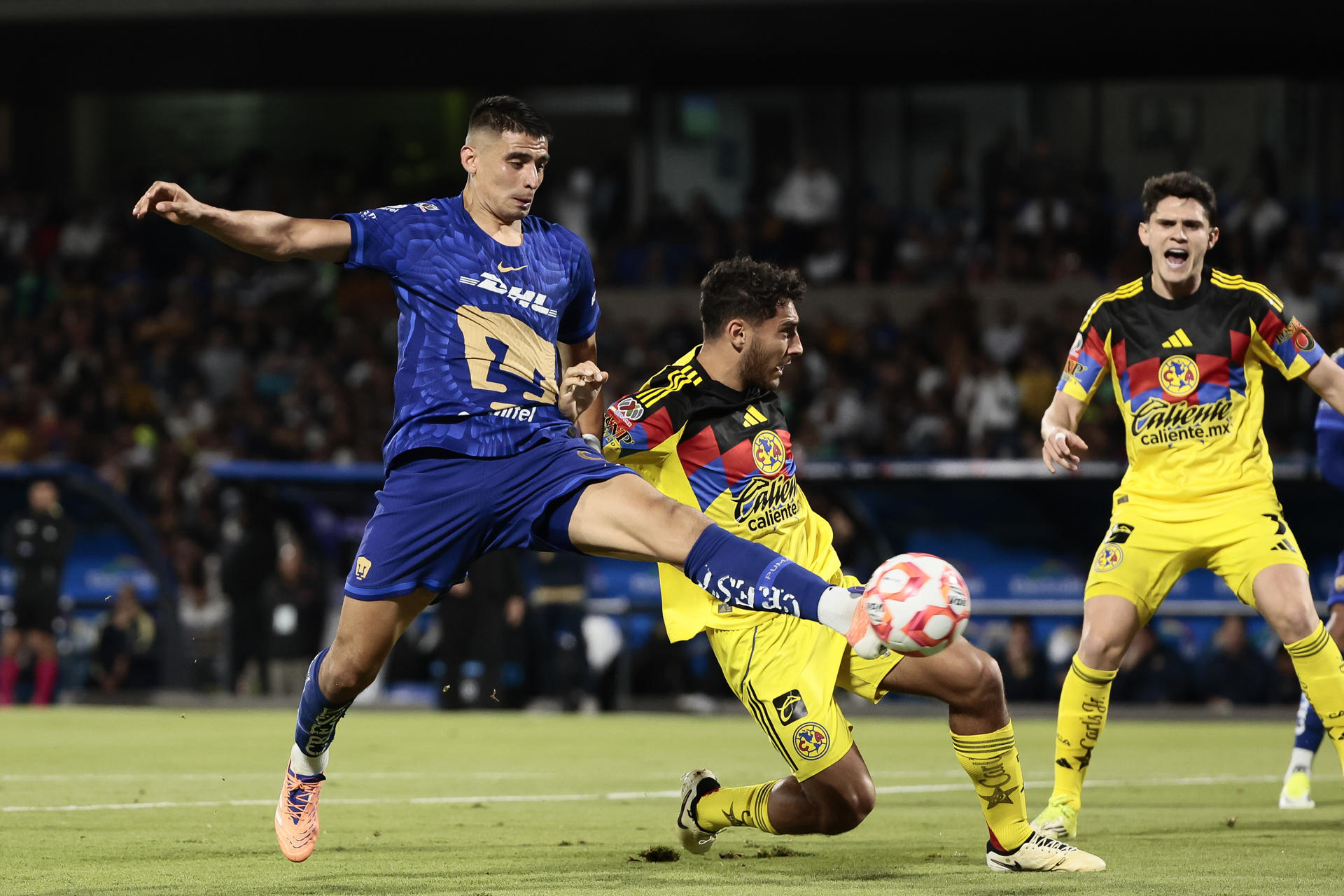 Guillermo Martínez (i) de Pumas disputa el balón con Sebastián Cáceres (d) de América este sábado en partido jugado en Ciudad de México. EFE/José Méndez