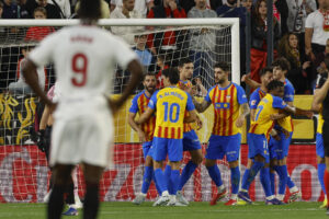 -Los jugadores del Valencia celebran el gol del centrocampista del Valencia Largie Ramazani contra el Sevilla, durante el partido de la jornada 29 de LaLiga EA Sports entre Sevilla y Valencia, este sábado en el estadio Sánchez- Pizjuán en Sevilla.-EFE/ Julio Muñoz