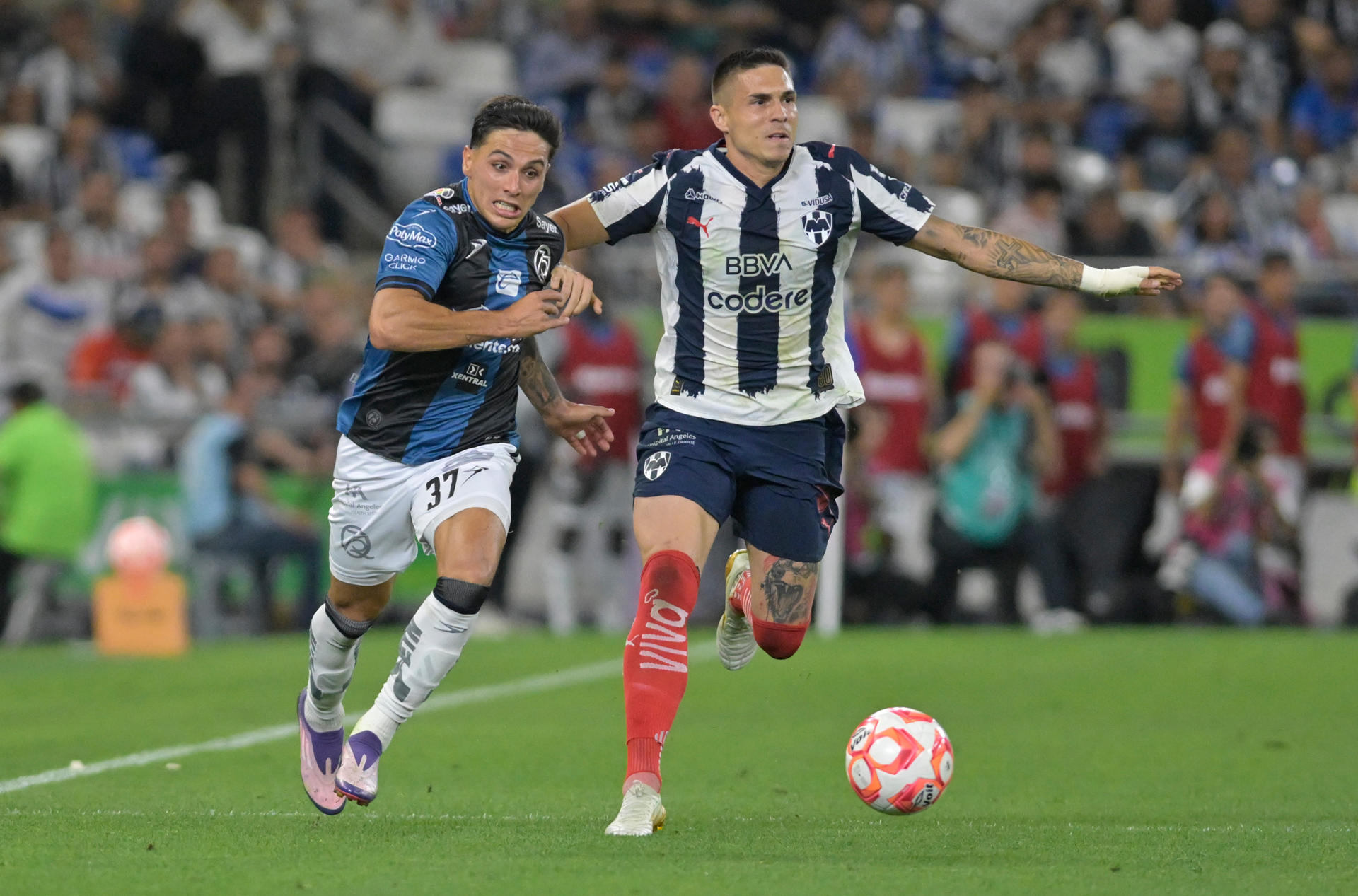 Uros Durdevic (d) de Monterrey disputa el balón con Mateo Coronel (i) de Queretaro este miércoles, durante un partido de la Liga MX entre monterrey y Queretaro en el estadio BBVA en Guadalupe (México). EFE/Miguel Sierra
