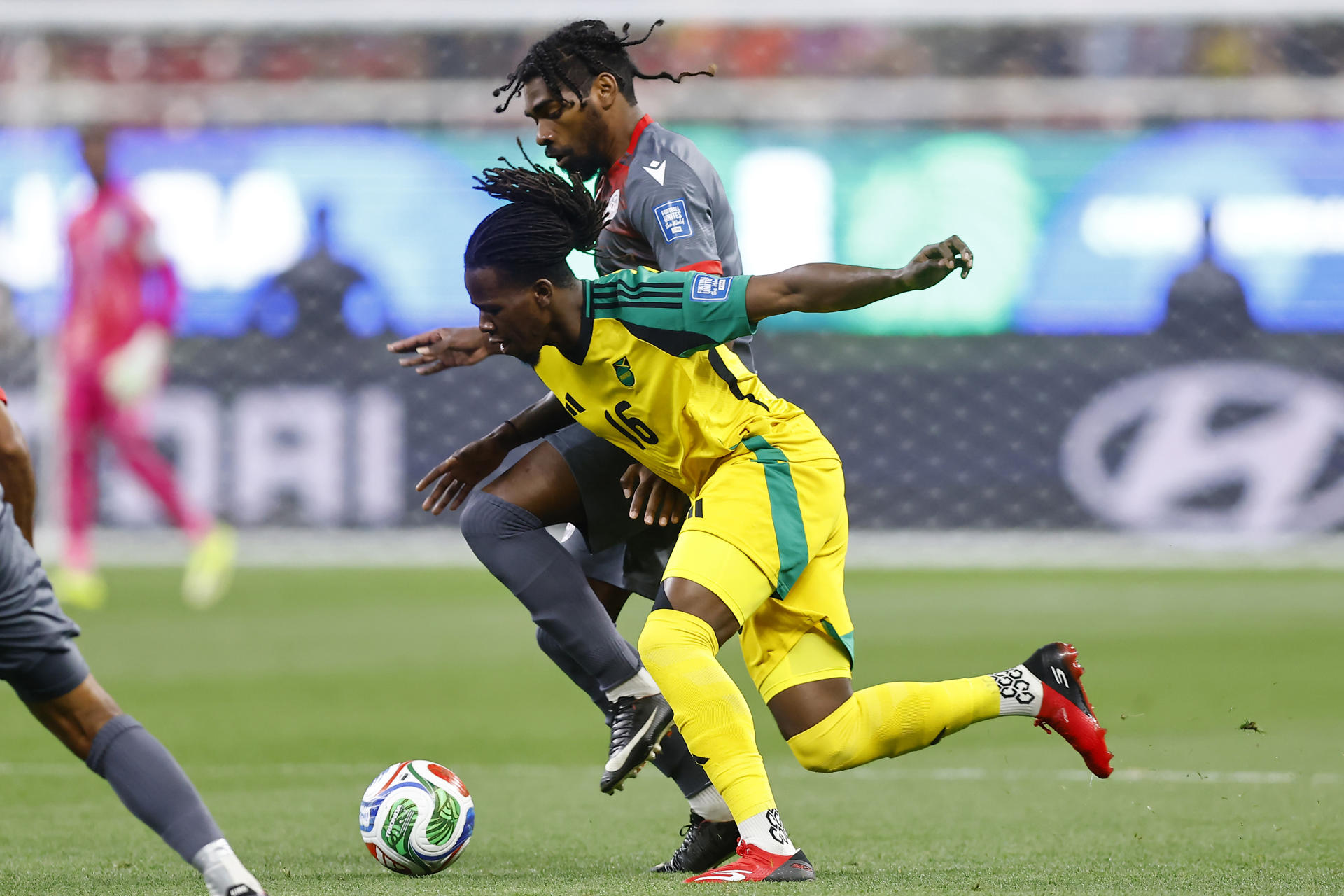 El neocaledonio Jean-Jacques Katrawa (atrás) forcejea por el control del balón con Karoy Anderson de Jamaica durante el partido de repesca para el Mundial jugado este jueves en el estadio Akron de la ciudad mexicana de Guadalajara. EFE/ Francisco Guasco