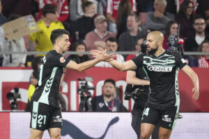 El centrocampista del Betis Marc Roca (i) celebra tras anotar el primer gol del equipo este martes, durante el partido de la jornada 33 de LaLiga EA Sports que disputan el Girona FC y el Real Betis en el Estadio Montilivi. EFE/ David Borrat