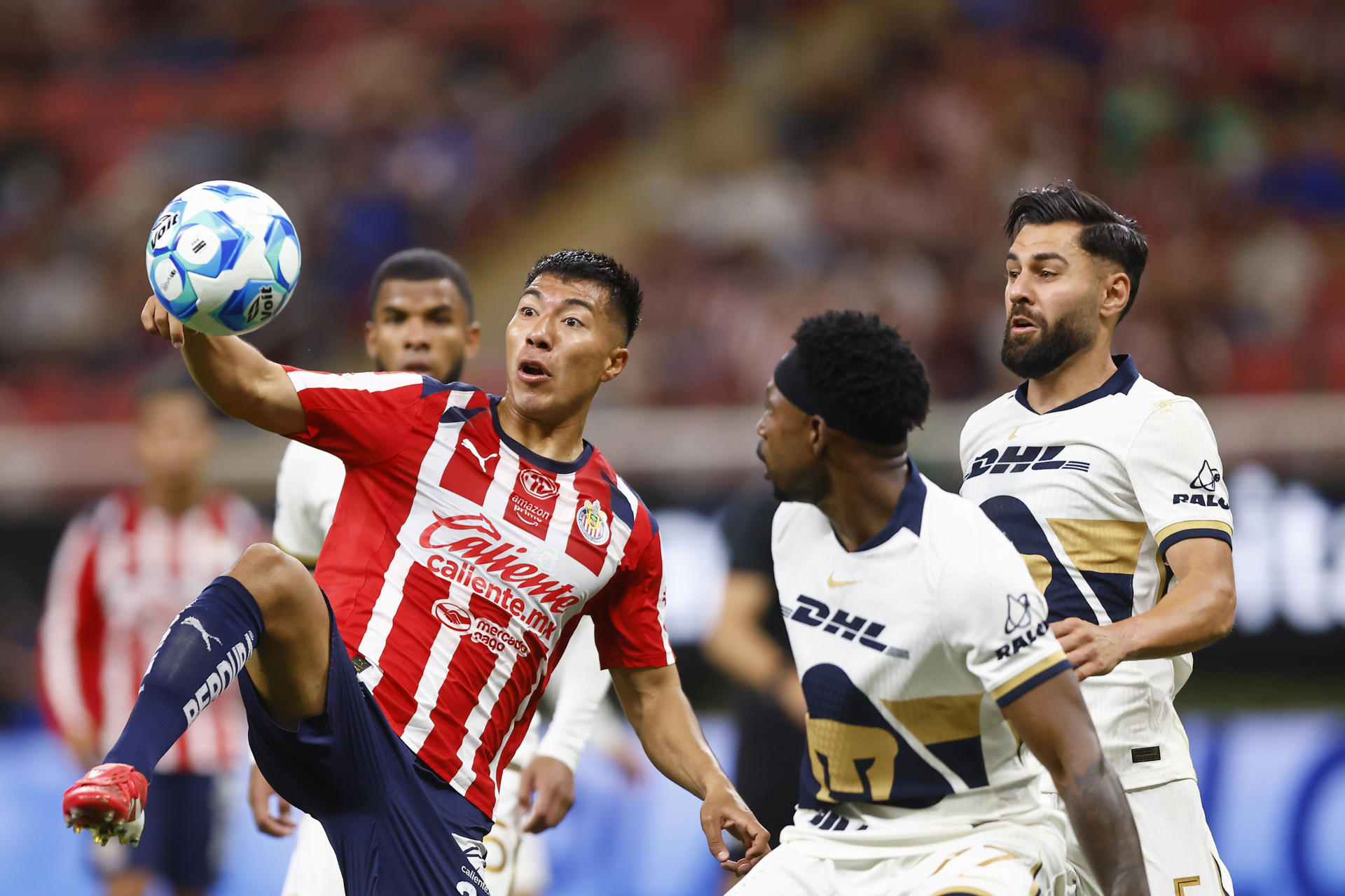 Daniel Aguirre (i), de Guadalajara,disputa el balón con Álvaro Angulo (c) y Rubén Duarte, de Pumas, durante un partido de la Liga MX entre Guadalajara y Pumas, en el Estadio Akron, en Guadalajara, Jalisco (México). EFE/ Francisco Guasco
