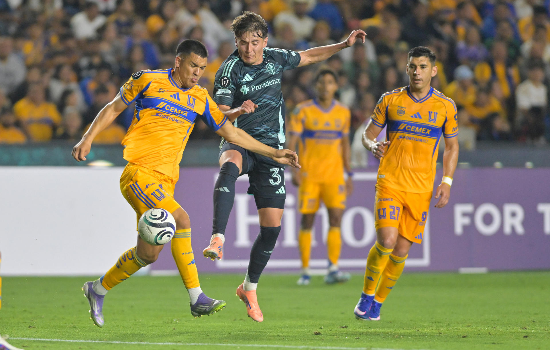 Cesar Araujo (i) de Tigres disputa el balón con Snyder Brunell (c) de Seattle Sounders este miércoles, durante un partido de cuartos de final de la Copa de Campeones de la Concacaf entre Tigres y Seattle Sounders en el estadio Universitario en San Nicolás de Los Garza (México). EFE/Miguel Sierra
