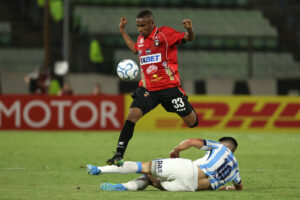 El mediocentro de Caracas Wilfred Correa elude por alto una barrida del defensor de Racing Ignacio Rodríguez durante el partido de la tercera jornada de la fase de grupos de la Copa Sudamericana que terminó 1-1 en el estadio Olímpico de la Universidad Central de Venezuela. EFE/ Miguel Gutiérrez