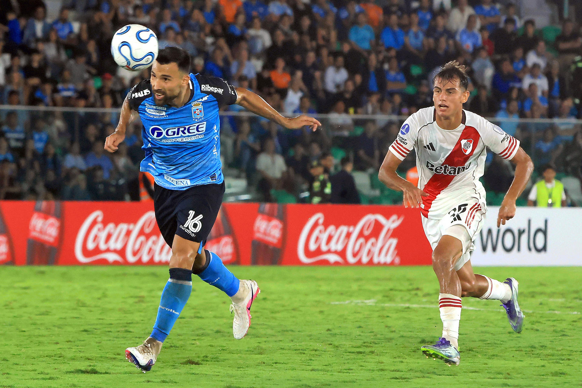 Danny Bejarano (i), de Blooming, disputa un balón con Joaquín Freitas, de River Plate, durante un partido de la fase de grupos de la Copa Sudamericana entre Blooming y River Plate en el estadio Ramón Tahuichi Aguilera Costas, en Santa Cruz (Bolivia). EFE/Juan Carlos Torrejón