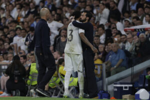 El defensa del Real Madrid Éder Militão (c) es consolado por el técnico Álvaro Arberloa tras abandonar el terreno de juego durante el partido contra el Alavés. EFE/ Juanjo Martín