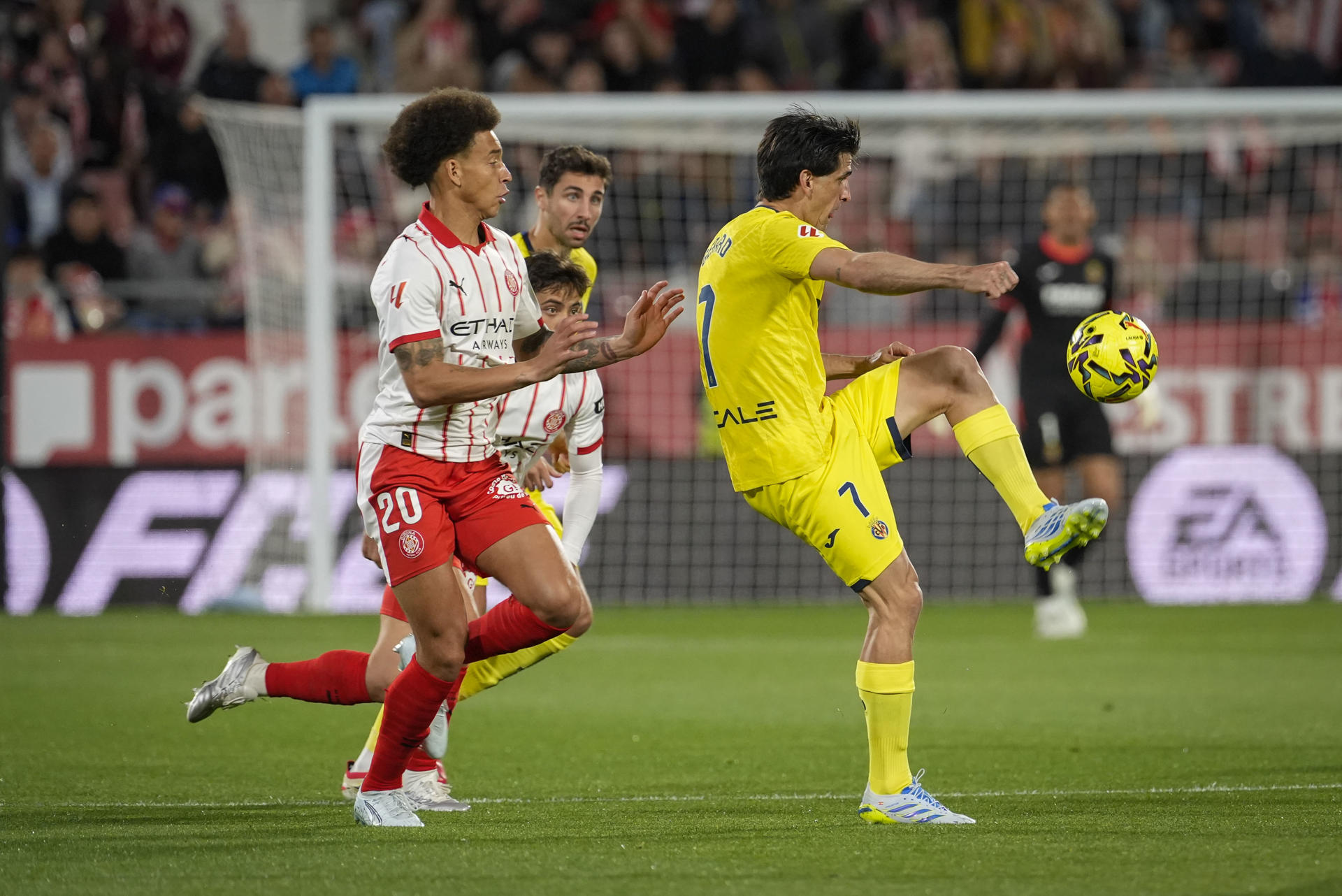 El centrocampista belga del Girona Axel Witsel (i) disputa un balón ante el delantero del Villarreal Gerard Moreno durante el partido de la jornada 30 de LaLiga EA Sports que disputan el Girona FC y el Villarreal CF este lunes, en el Estadio Montilivi de Girona (Cataluña). EFE/ David Borrat