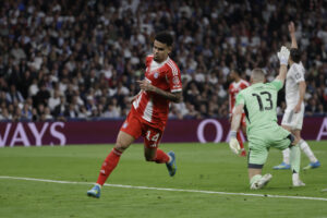 El delantero colombiano del Bayern Munich Luis Díaz celebra tras anotar el primer gol del equipo durante el encuentro correspondiente a la ida de los cuartos de final de la Liga de Campeones que disputaron Real Madrid y Bayern Munich en el estadio Santiago Bernabéu, en Madrid. EFE/Juanjo Martín.