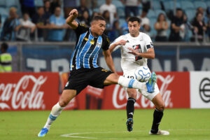 Carlos Vinícius (i), de Gremio, domina el balón por delante de Juan Randazzo, de Deportivo Riestra, este martes durante un partido de la Copa Sudamericana en el estadio Arena do Gremio, en Porto Alegre (Brasil). EFE/ Ricardo Rimoli