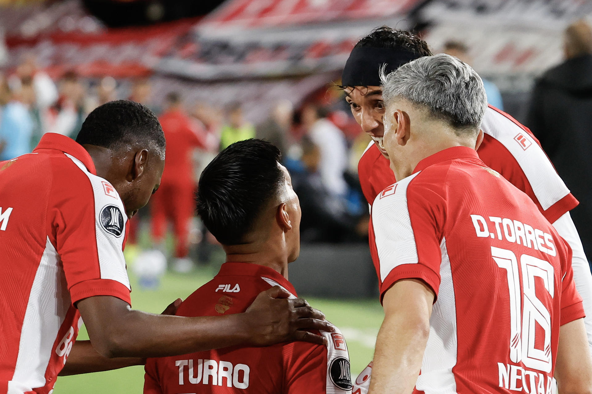 Jugadores de Santa Fe celebran este jueves el gol del argentino Emanuel Oliveira (c) que puso en ventaja al equipo bogotano en el partido contra Peñarol que cerró este jueves la fase de grupos de la Copa Llibertadores en el estadio El Campín. EFE/ Mauricio Dueñas Castañeda
