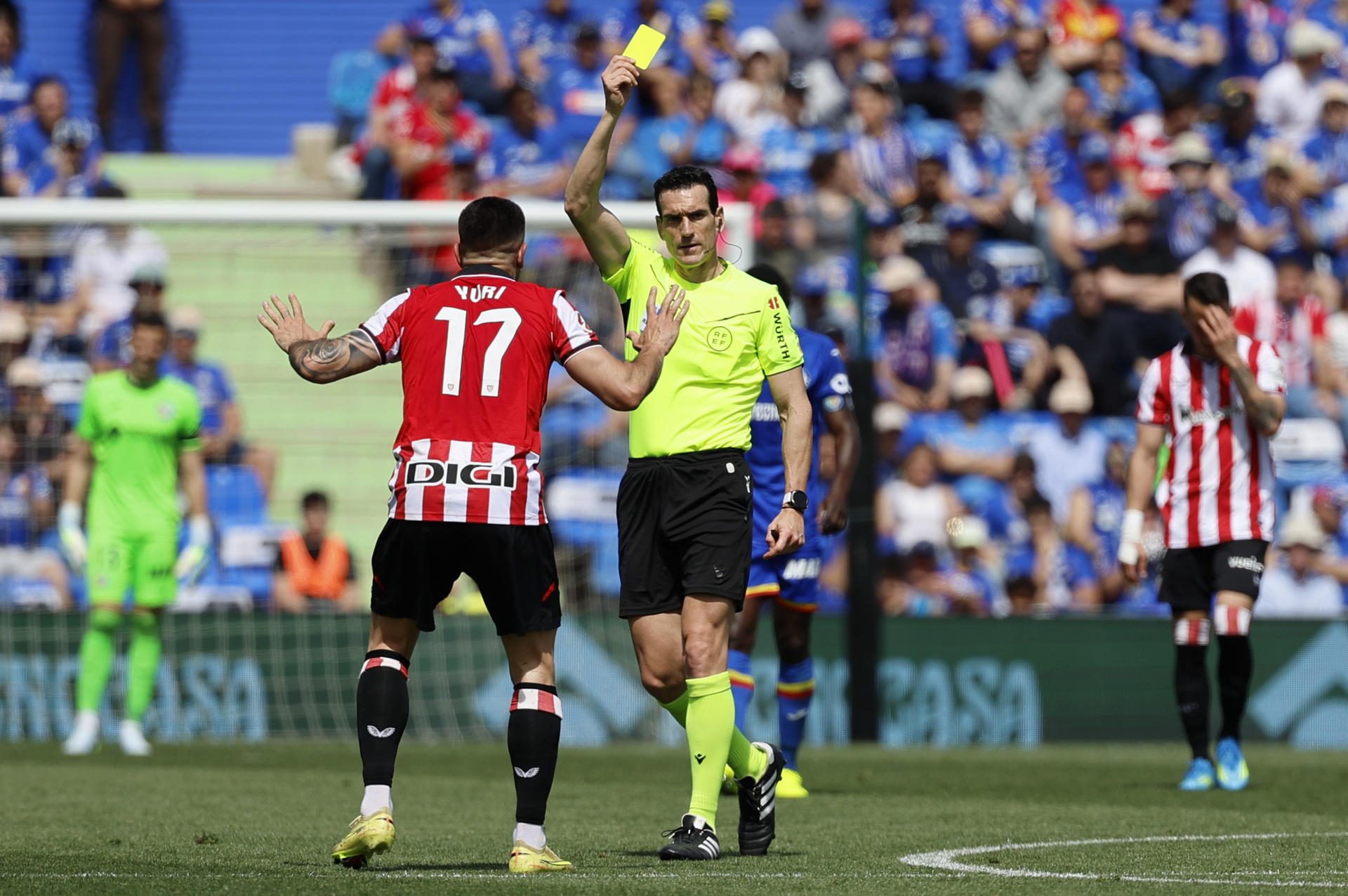 El árbitro Martínez Munuera muestra tarjeta amarilla al defensa del Athlétic de Bilbao Yuri, durante el partido ante el Getafe de LaLiga EA Sports disputado en el Estadio Coliseum de Getafe este domingo. EFE/ Mariscal
