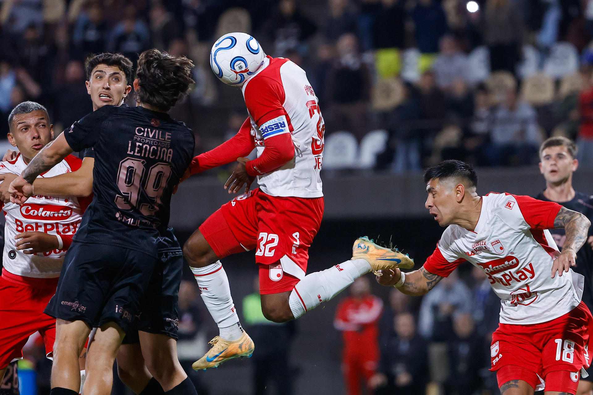Gonzalo Lencina, de Platense, disputa el balón con Christian Mafla (c), de Santa Fe, en la Copa Libertadores. EFE/Juan Ignacio Roncoroni
