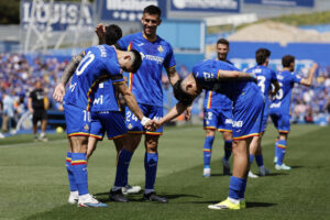 El futbolista del Getafe CF Martín Satriano (i) felicita a su compañero Luis Vázquez (d) tras marcar éste el 1-0 al Athlétic de Bilbao durante el partido de LaLiga EA Sports disputado en el Estadio Coliseum de Getafe este domingo. EFE/ Mariscal