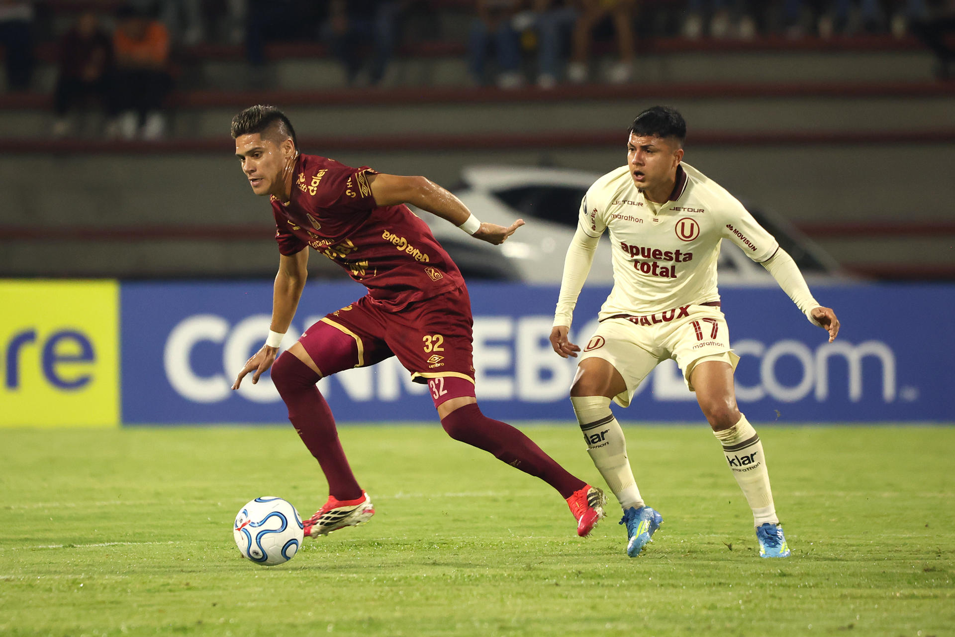 Sebastián Guzmán (i), de Tolima, avanza ante la marca de Jairo Concha, de Universitario, en el estadio Manuel Murillo Toro. EFE/ Agencia Unido360