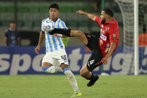 El defensor de Caracas Jesús Quintero (d) se exige al máximo para ganar un balón dividido al extremo de Racing Club Tomás Agustín Pérez este miércoles, durante el partido de la tercera jornada de la fase de grupos de la Copa Sudamericana jugado en el estadio Olímpico de la Universidad Central de Venezuela. EFE/ Miguel Gutiérrez