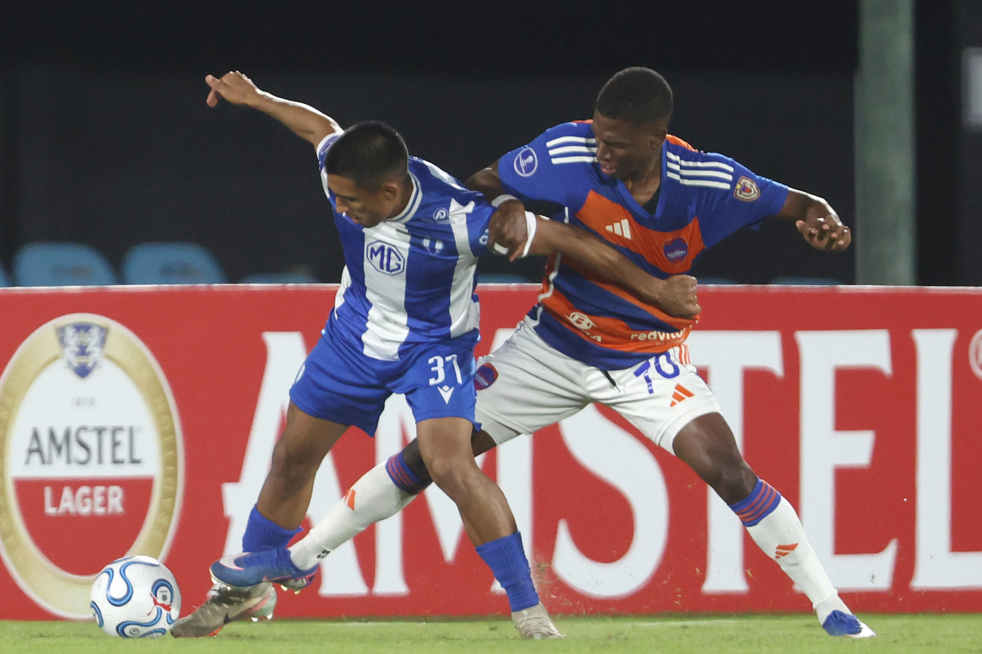 Ramiro Miguel Peralta (i), de Juventud, disputa un balón con Robinson Flores, de Puerto Cabello, en un partido de la fase de grupos de la Copa Sudamericana entre Juventud y Puerto Cabello en el Estadio Centenario de Montevideo (Uruguay). EFE/Gastón Britos
