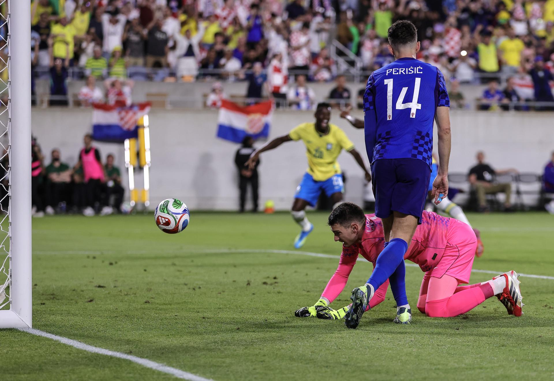 El guardameta de la selección de Croacia, Dominik Livakovic, mira derrotado el ingreso del balón a su portería durante el partido de preparación para el Mundial que ganó Brasil este miércoles en Orlando (Florida). EFE/EPA/CRISTOBAL HERRERA-ULASHKEVICH
