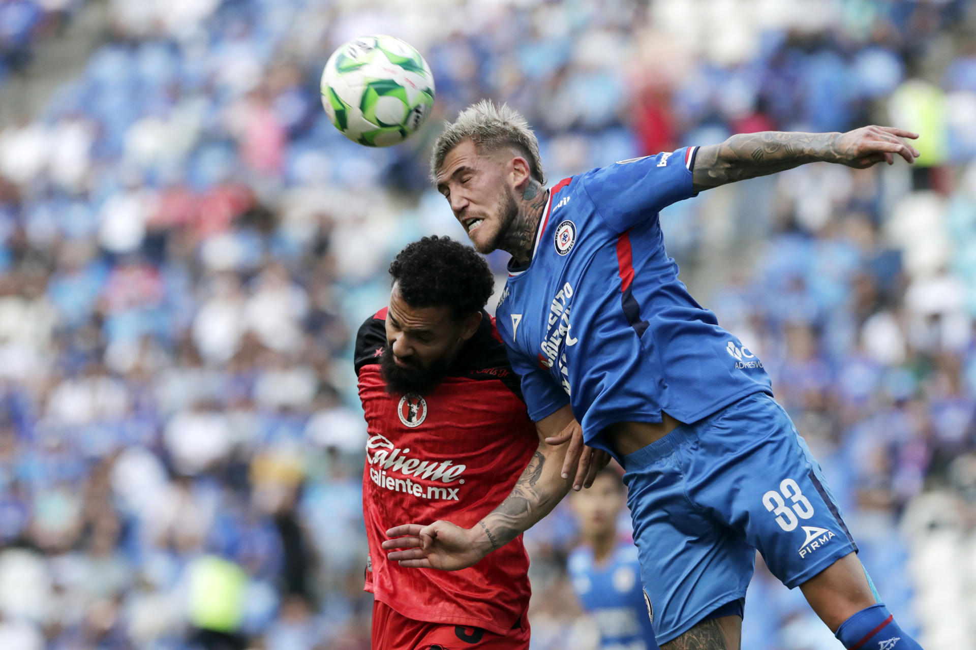 Gonzalo Piovi (d), de Cruz Azul, disputa un balón con Mourad El Ghezouani, de Tijuana, durante un partido por la jornada 15 del torneo Clausura 2026 de la Liga MX en el estadio Cuauhtémoc en Puebla (México). EFE/Hilda Ríos 