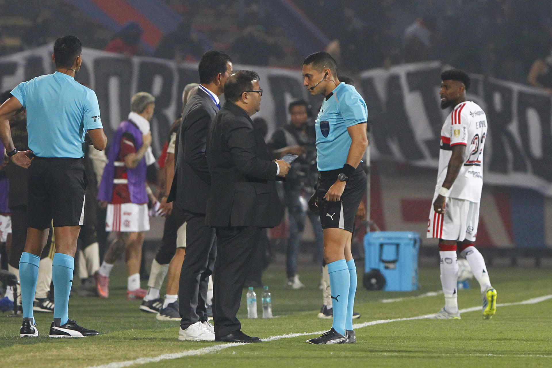 El árbitro venezolano Jesús Valenzuela (c-d) habla este jueves con un delegado de la Conmebol antes de anunciar la cancelación del partido de la cuarta jornada de la fase de grupos de la Copa Libertadores entre Independiente Medellín y Flamengo por desórdenes provocados por fanáticos del equipo colombiano en una de las tribunas del estadio Atanasio Girardot. EFE/ STR
