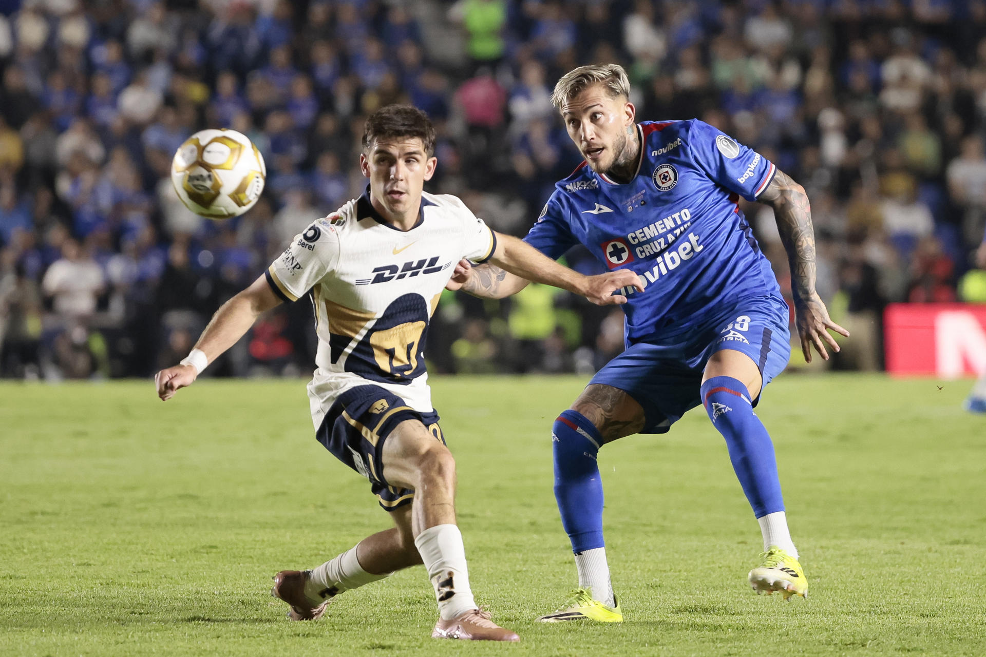 Gonzalo Piovi (d) de Cruz Azul disputa el balón con Santiago Trigos de Pumas este jueves, en el partido de ida de la final de la Liga MX entre Cruz Azul y Pumas en el estadio Ciudad de los Deportes en Ciudad de México (México). EFE/ José Méndez