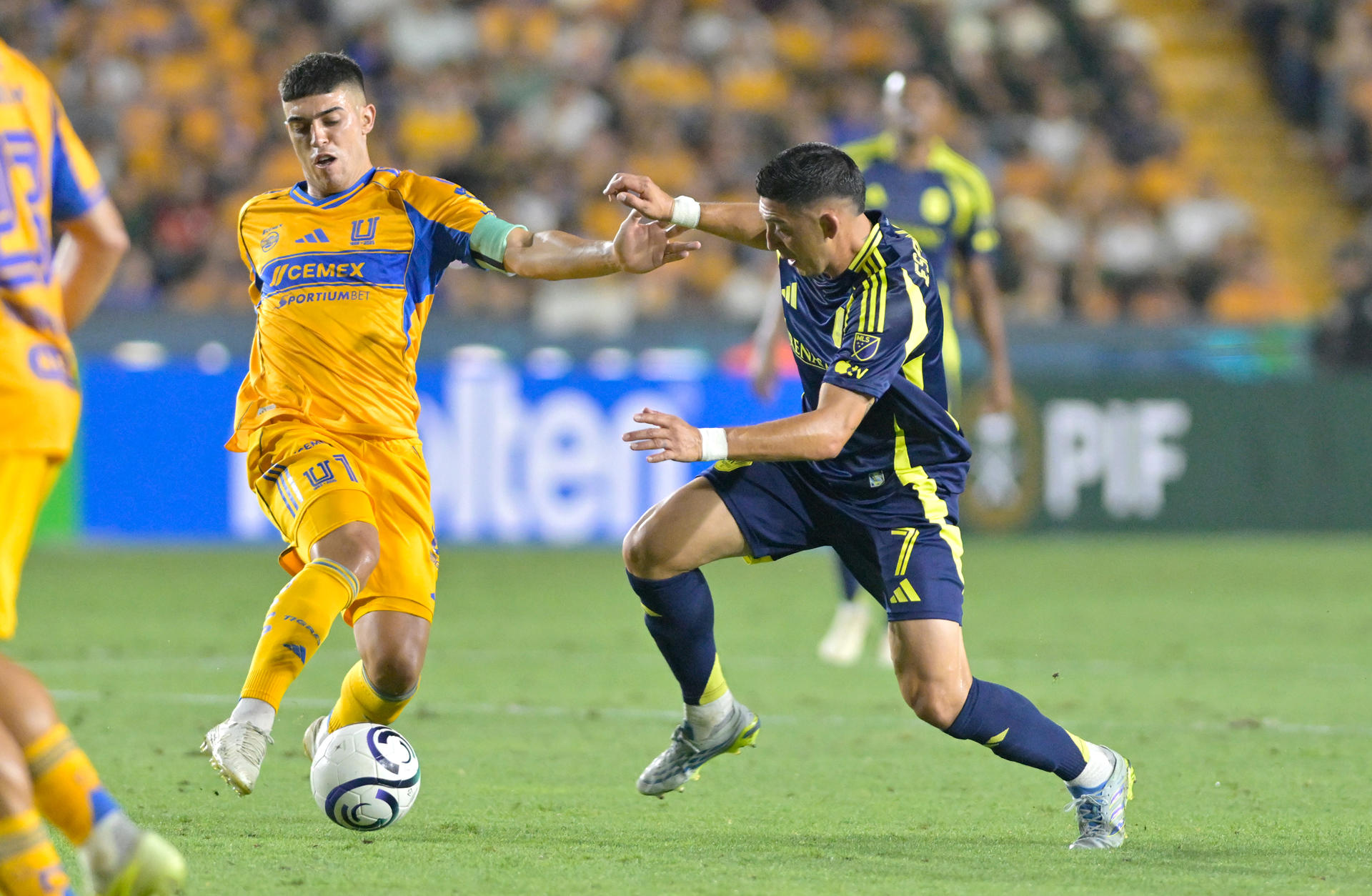 Juan Brunetta (i) de Tigres disputa el balón con Cristian Espinoza de Nashville SC este martes, en un partido de la semifinal de la Copa de Campeones Concacaf en el estadio Universitario en San Nicolás de los Garza (México). EFE/ Miguel Sierra
