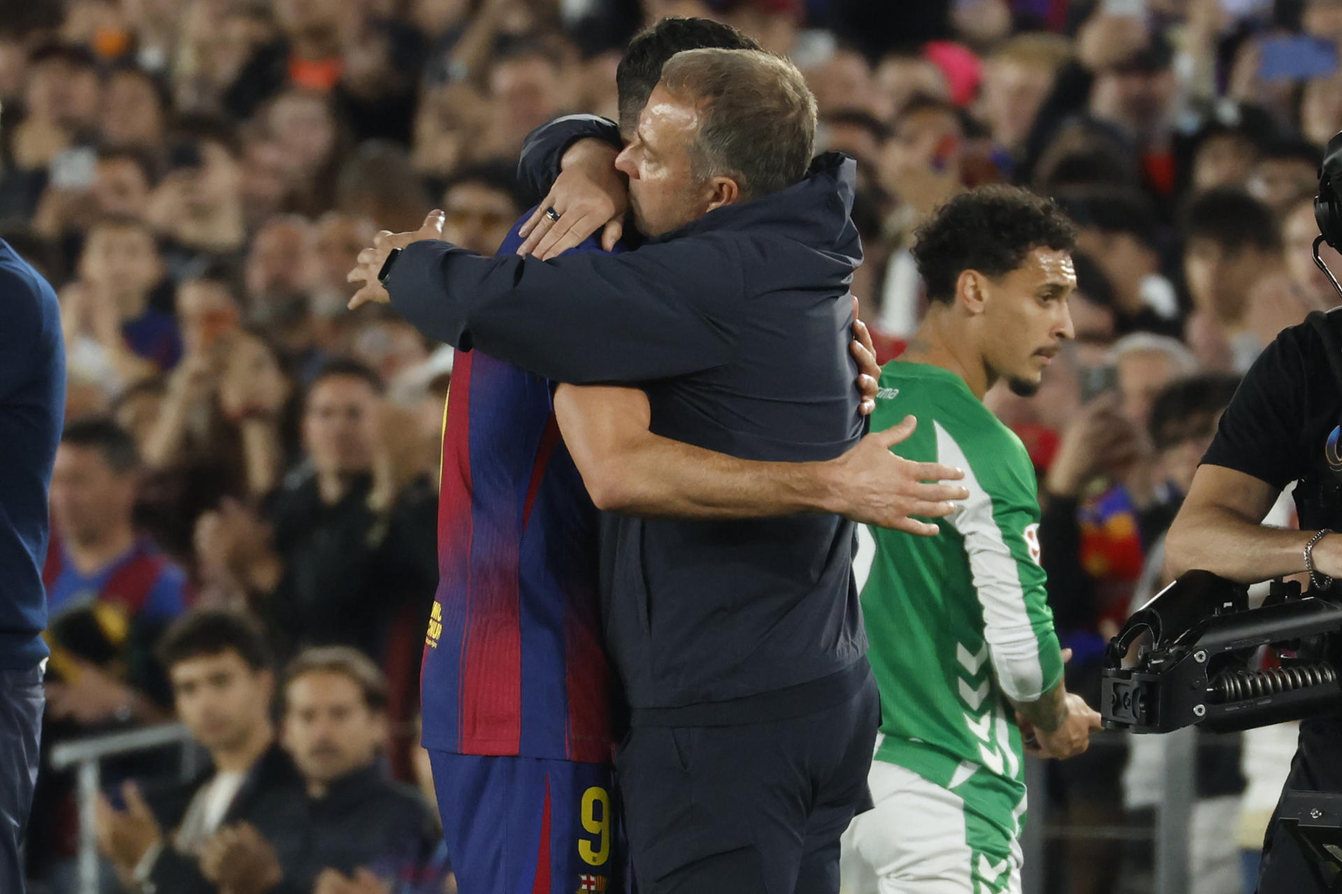 El entrenador del Barcelona, Hansi Flick (d), se abraza con Robert Lewandowski al ser sustituido, durante el partido de la jornada 37 de LaLiga que FC Barcelona y Real Betis disputan este domingo en el Camp Nou. EFE/Marta Pérez
