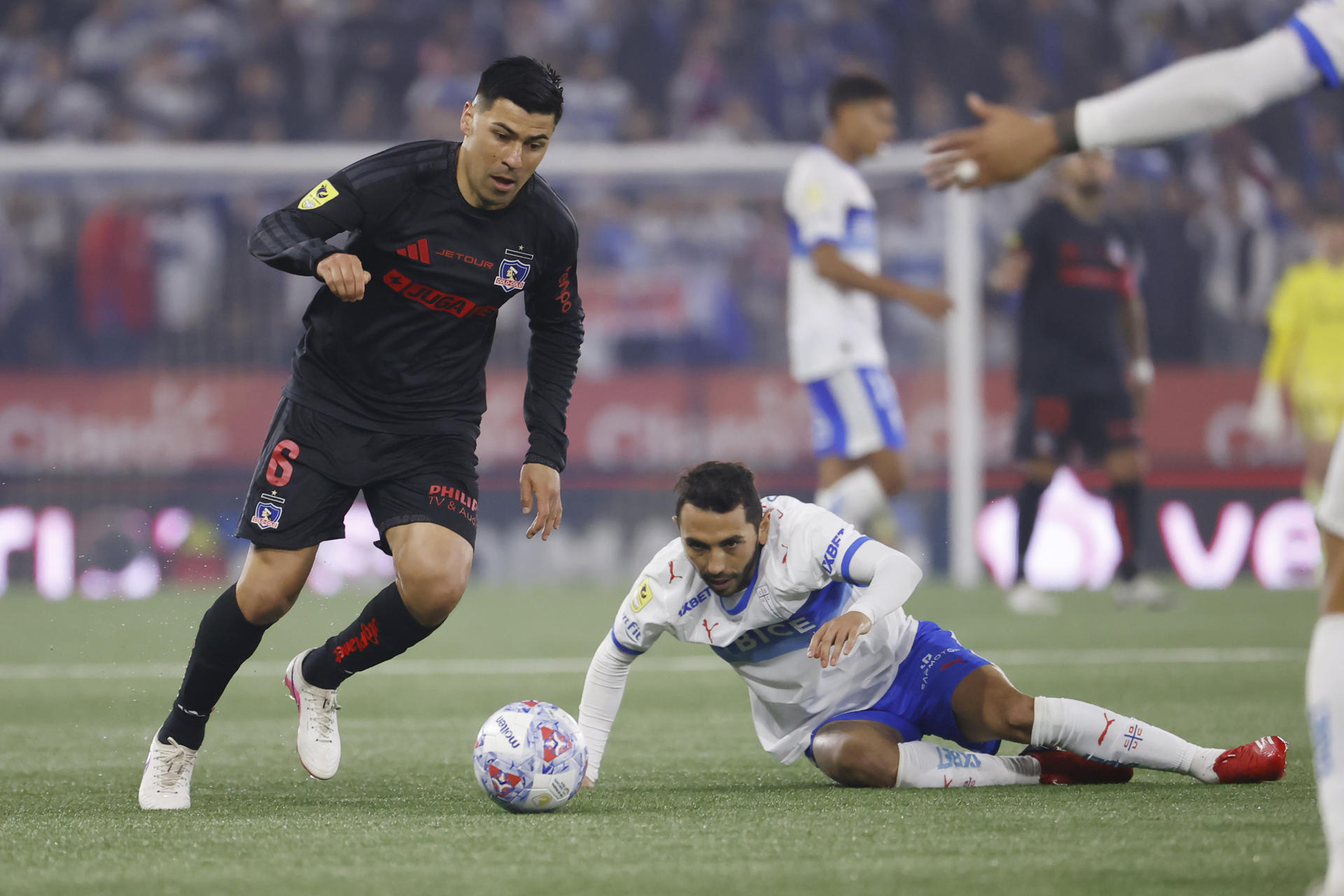 Cristián Cuevas (d), de Universidad Católica, disputa un balón con Tomás Alarcón, de Colo-Colo, en un partido de la Liga de Primera entre Universidad Católica y Colo-Colo en el estadio Claro Arena en Santiago (Chile). EFE/Elvis González