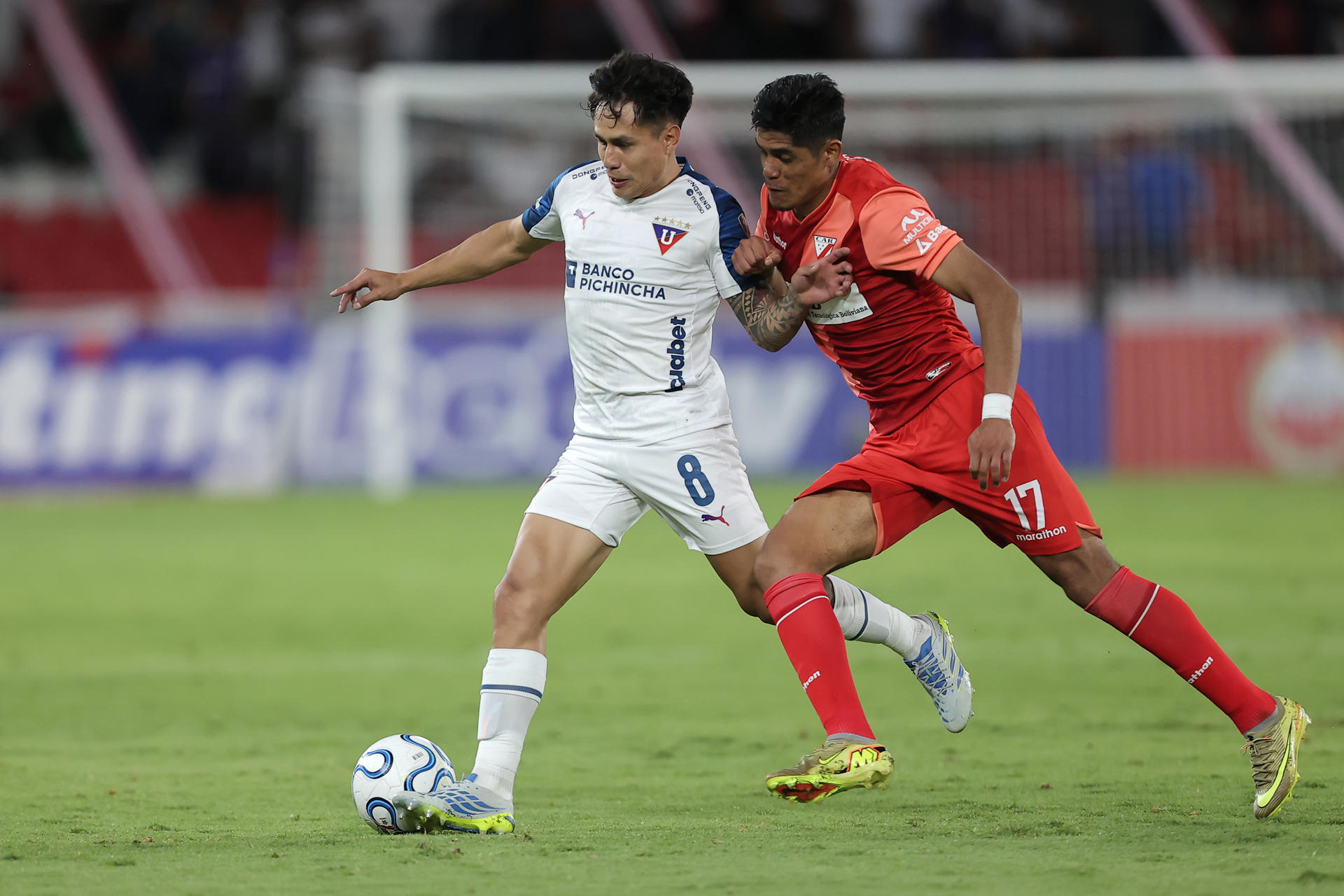 Jesús Pretell (i), de LDU Quito, disputa el balón con Fernando Nava, de Always Ready, durante un partido de la fase de grupos de la Copa Libertadores entre LDU Quito y Always Ready en el estadio Rodrigo Paz Delgado en Quito (Ecuador). EFE/José Jácome