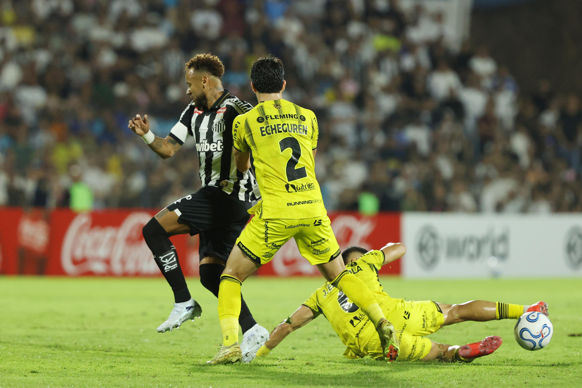 Facundo Echeguren (c) y José Antonio Espinola (d), de Recoleta, disputan el balón con Neymar, de Santos, este martes en un partido de la Copa Sudamericana en el estadio Río Parapití, en Pedro Juan Caballero (Paraguay). EFE/ Juan Pablo Pino
