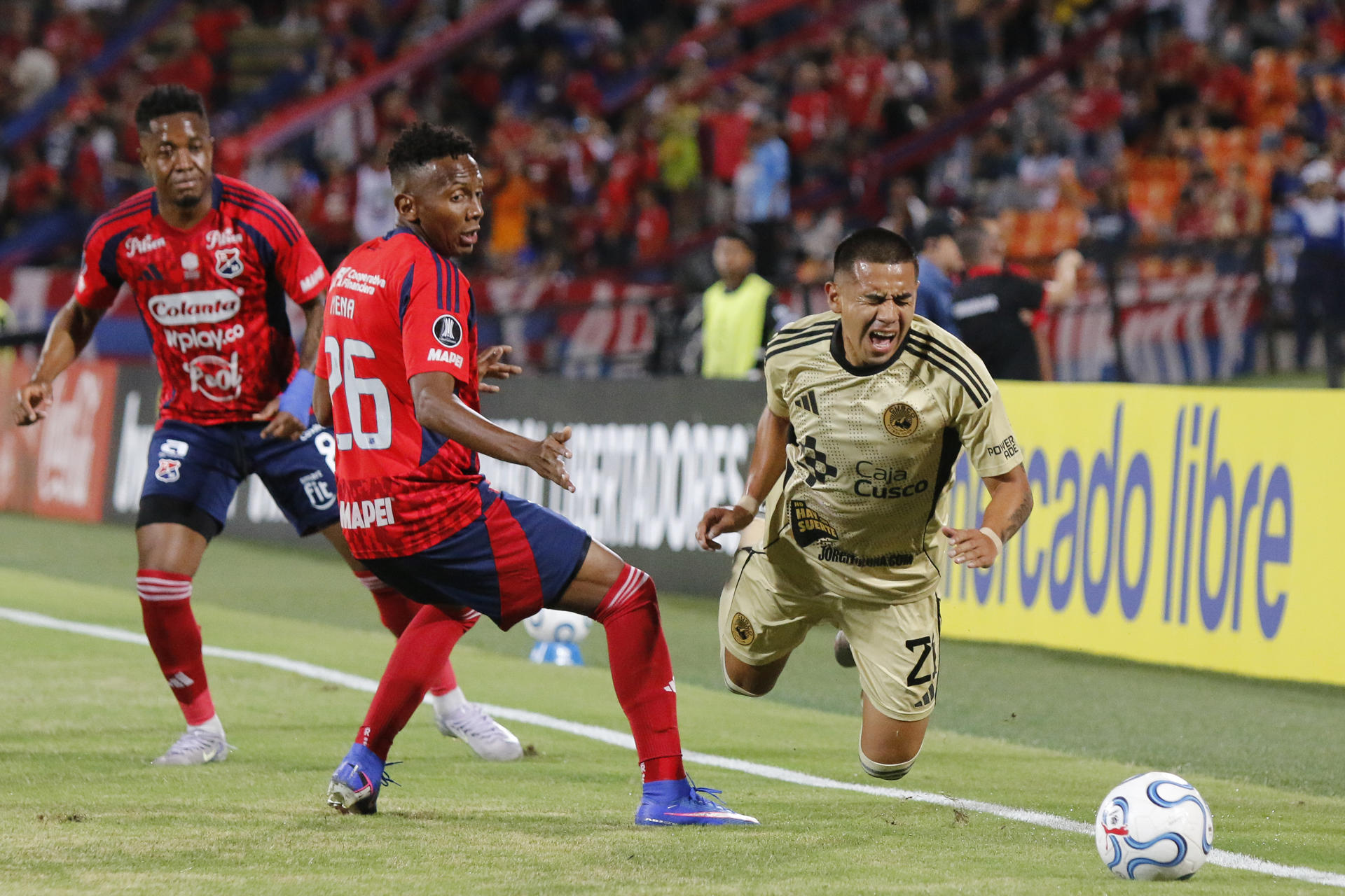 Esneyder Mena (c), del Medellín, comete falta contra José Zevallos, del Cusco,en el estadio Atanasio Girardot en Medellín. EFE/STR 