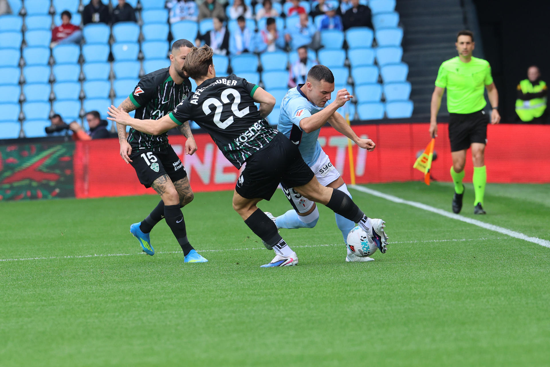 El delantero del Celta de Vigo Ferran Jutglà (d) lucha por el balón con el defensa David Affengruber (c), del Elche, durante el partido de LaLiga disputado este domingo en el Estadio Abanca-Balaídos de Vigo. EFE/ Salvador Sas 