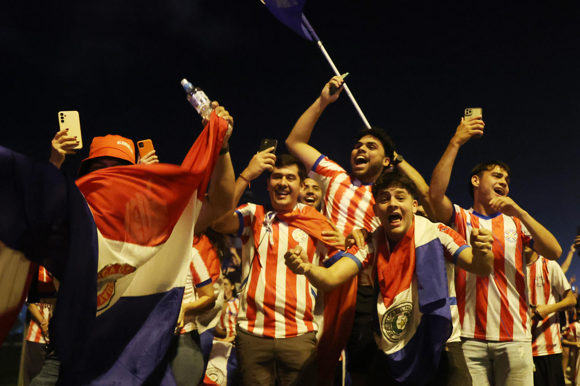 Aficionados de Paraguay despiden a su selección rumbo al Mundial de 2026 este sábado en el aeropuerto Silvio Pettirossi, en Luque. EFE/ Juan Pablo Pino