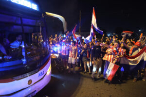 Aficionados de Paraguay despiden a su selección rumbo al Mundial de 2026 este sábado en el aeropuerto Silvio Pettirossi, en Luque. EFE/ Juan Pablo Pino