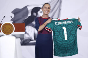 La presidenta de México, Claudia Sheinbaum, posa con una camiseta de la selección de México este lunes, durante una rueda de prensa en el Palacio Nacional de Ciudad de México (México). EFE/ Sáshenka Gutiérrez