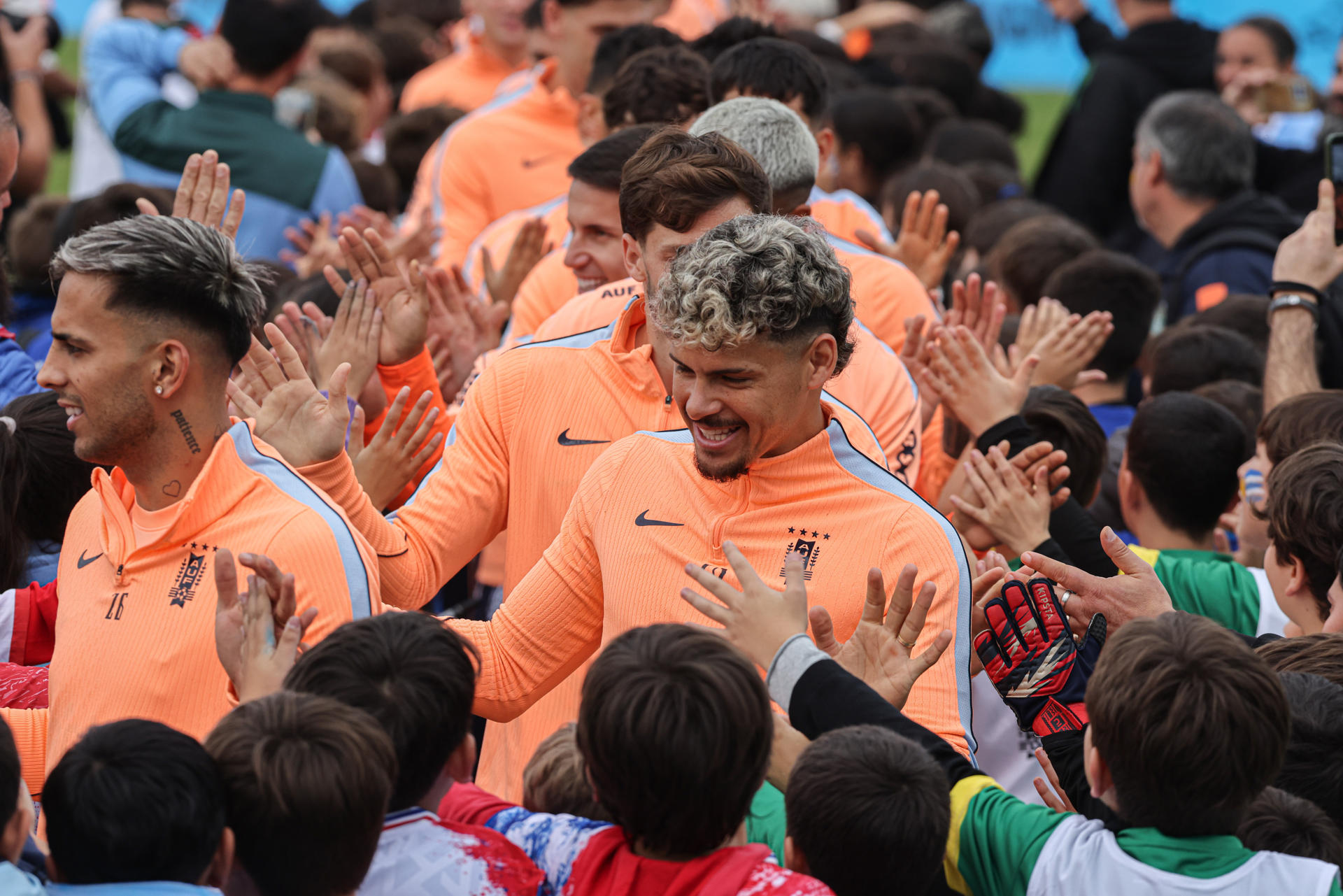 Jugadores de la selección de fútbol de Uruguay saludan niños durante un evento de despedida este viernes en el estadio Tito López López, en Pando, Canelones. EFE/ Gastón Britos